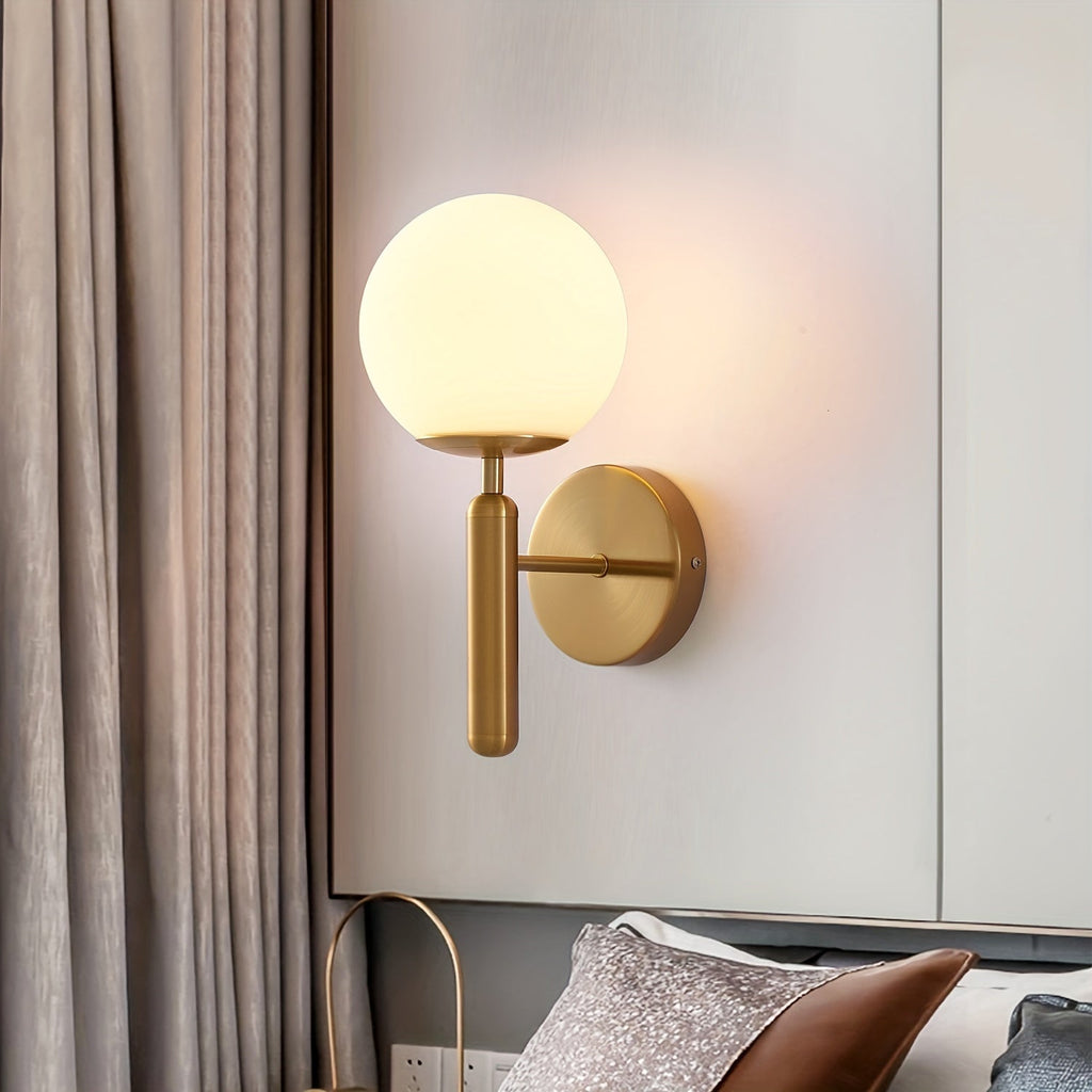 Moderní nástěnná lampa s kulatým skleněným stínidlem a leštěným kovovým držákem