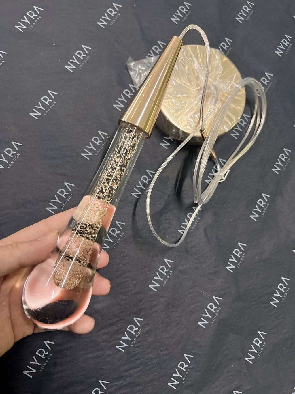 Auric-kultainen pisaravalaisin kristallipinnalla