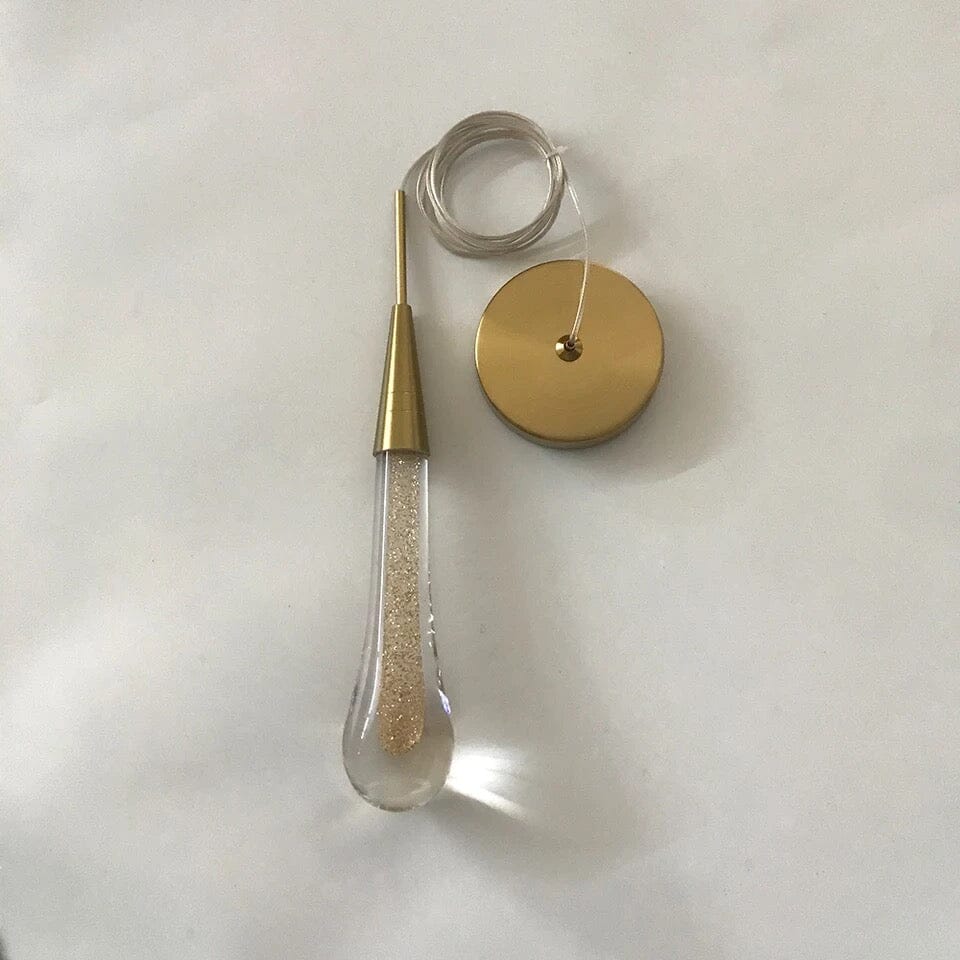 Auric-kultainen pisaravalaisin kristallipinnalla