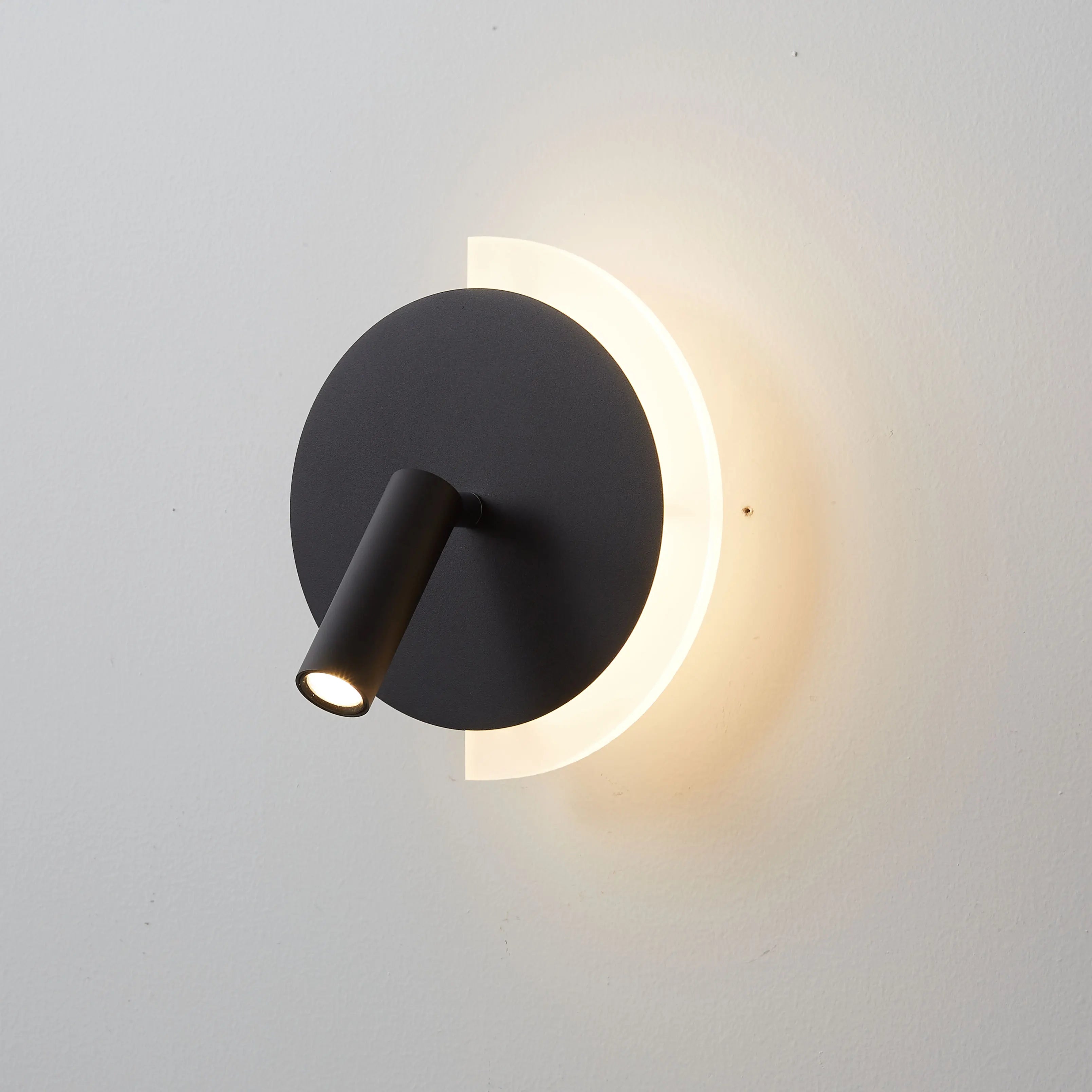 Nástěnné světlo LunaSpot LED u postele s minimalistickým designem
